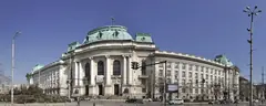 Ректоратът на Софийския университет „Св. Климент Охридски“ със зелени куполи и българско знаме под синьо небе